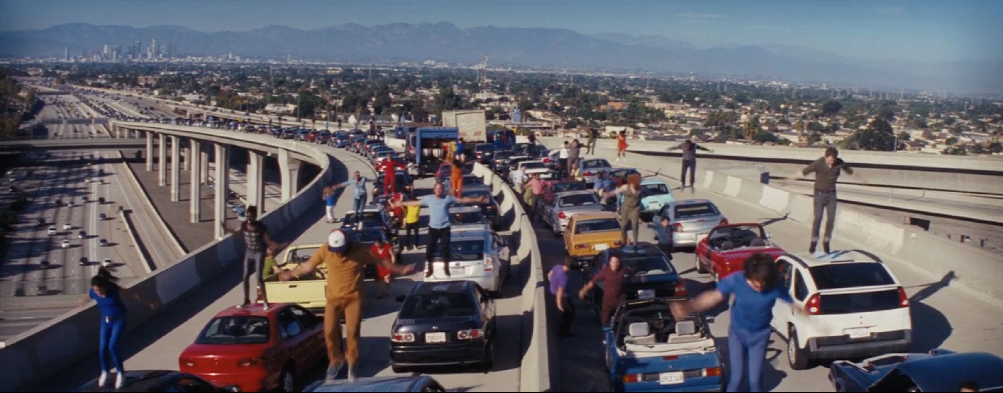 A wide view of a crowded highway with distant landscape visible around the people