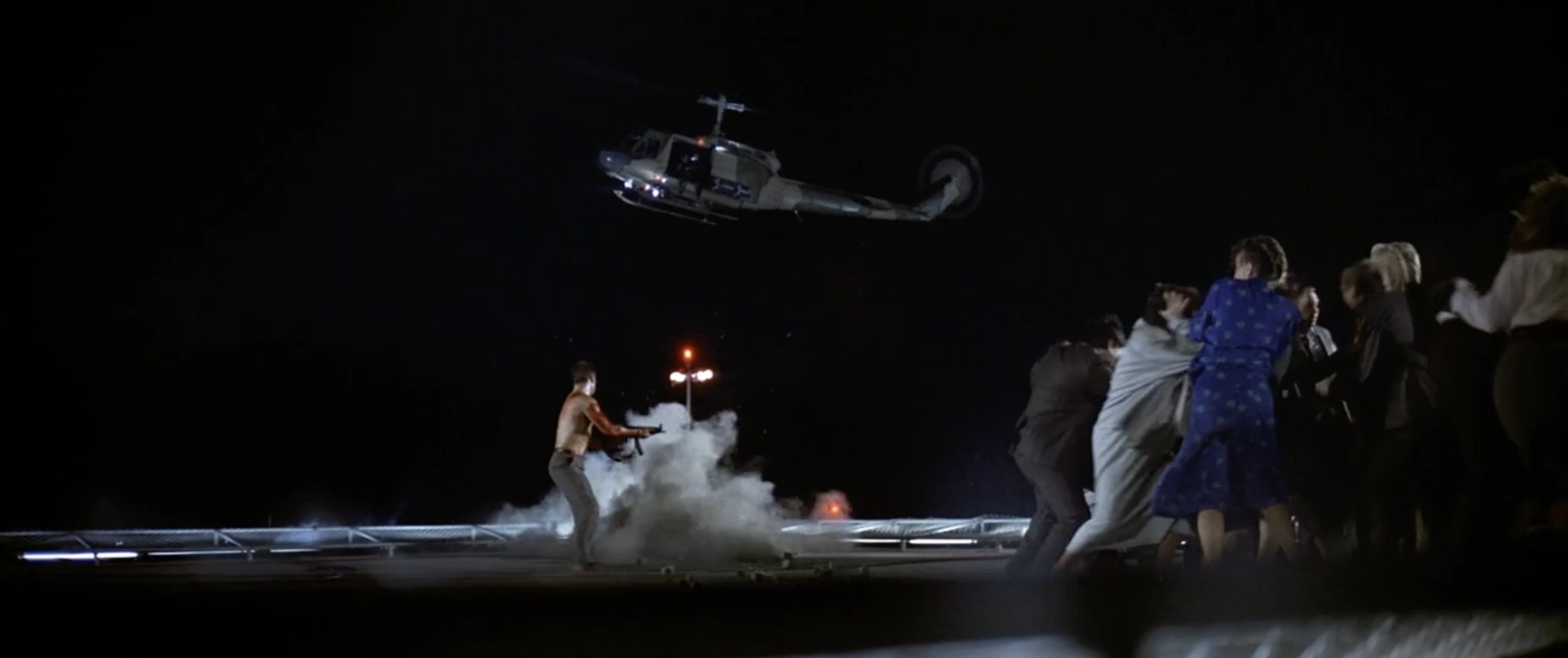 Wide frame showing several dancers and a helicopter across the scene